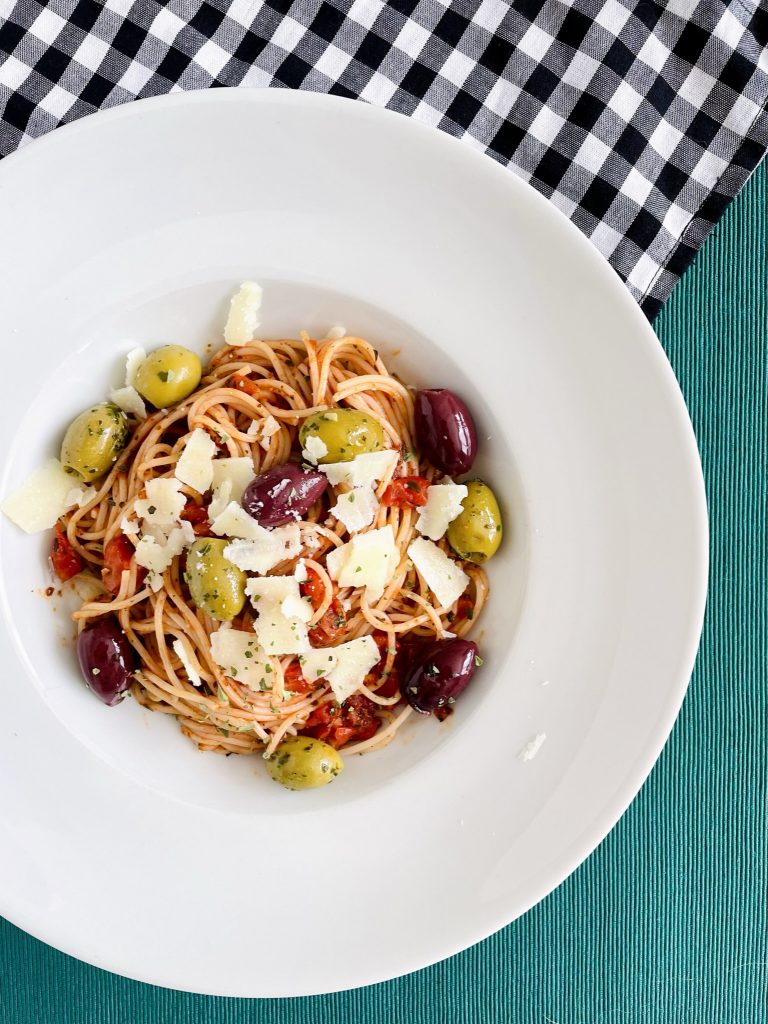 Spaghetti met olijven op een mooi diep wit bord